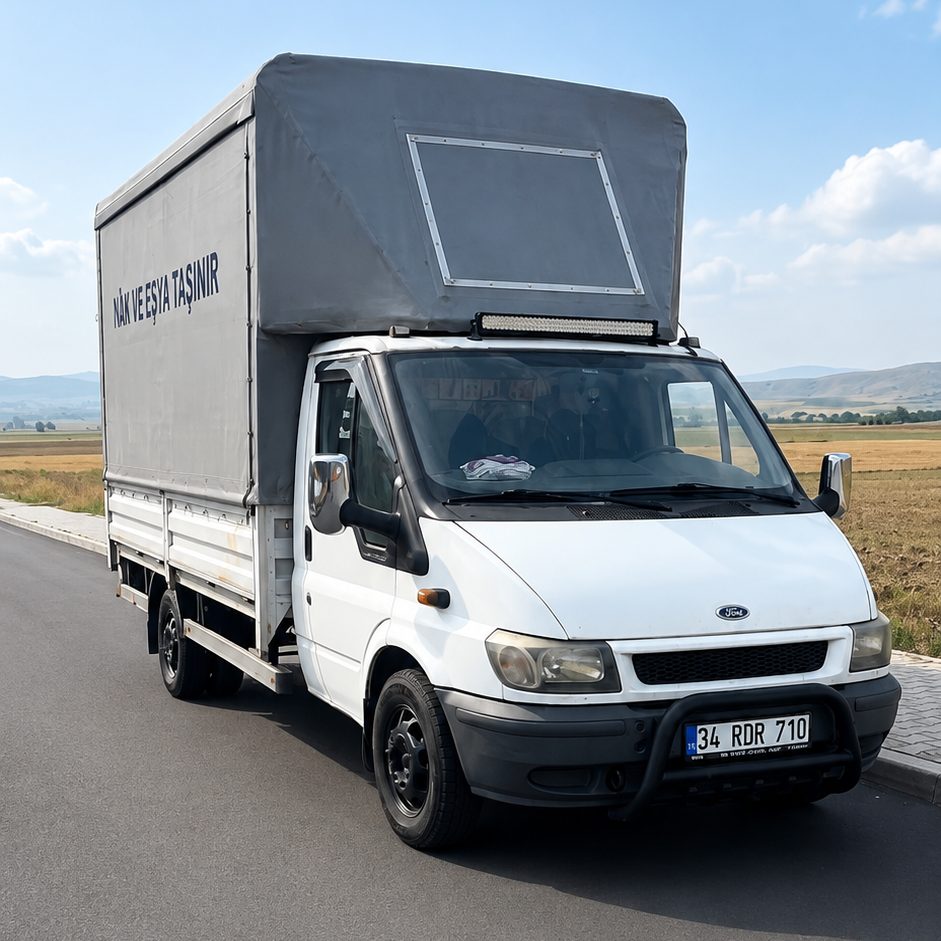 Karamanlı Nakliyat'a ait Ford Transit kamyonet; brandayla kapatılmış açılır kanatlı nakliyat kasası, kasanın yanında firma yazısı.